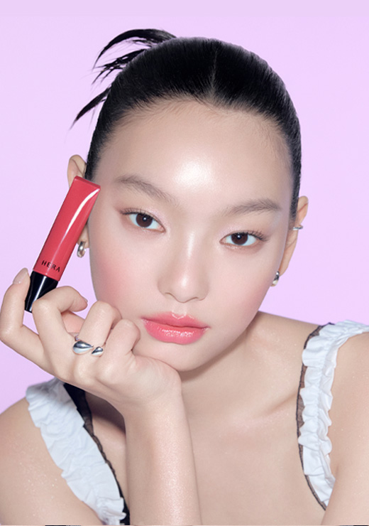 센슈얼 틴티드 샤인 립 세럼을 들고 있는 모델