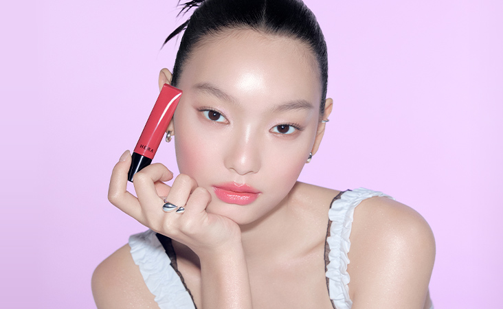 센슈얼 틴티드 샤인 립 세럼을 들고 있는 모델